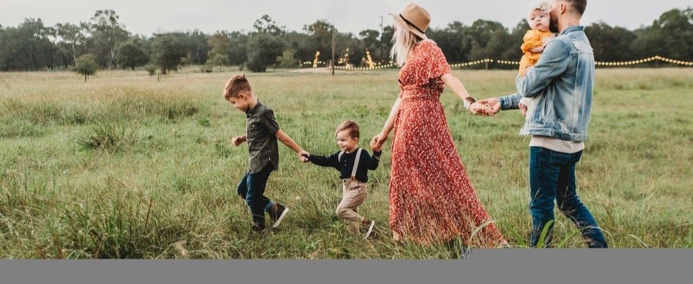 A family walking through a meadow at dusk